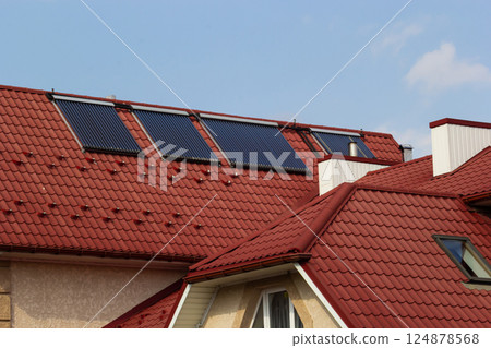 Solar panels installed on red roofs in a sunny residential area during daytime Solar panels installed on red roofs in a sunny residential area during daytime 124878568