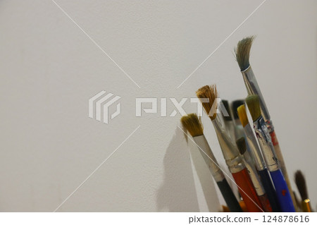 Artistic tools arranged on a studio surface ready for creative projects using brushes of various shapes and sizes Artistic tools arranged on a studio surface ready for creative projects using brushes of various shapes and sizes 124878616