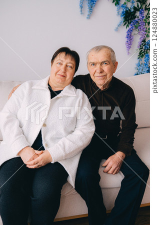Elderly Couple Sitting Together on a Couch at Home Elderly Couple Sitting Together on a Couch at Home 124880023