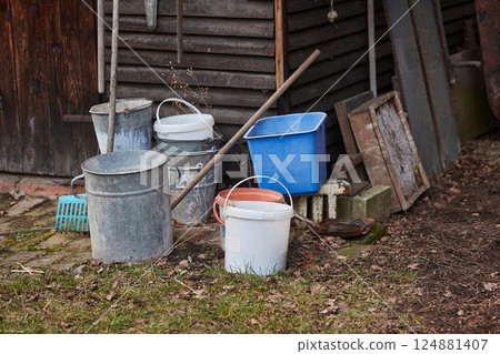 Buckets and tools by the shed on a farmstead backyard 124881407