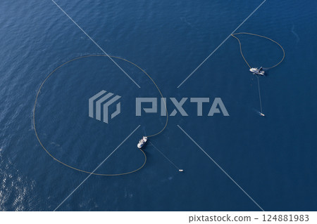 A bird's eye view of a large fishing vessel retrieving its nets.  124881983