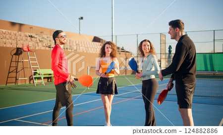 Young adults teaching and learning how to play pickleball 124882886