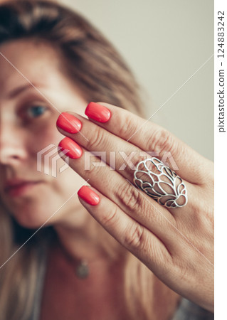 Beautiful mid age woman showing red shellac manicure on nails . Beautiful mid age woman showing red shellac manicure on nails . 124883242
