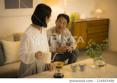 Middle-aged couple in the living room at night Middle-aged couple in the living room at night 124883486