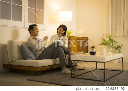 Middle-aged couple in the living room at night Middle-aged couple in the living room at night 124883492
