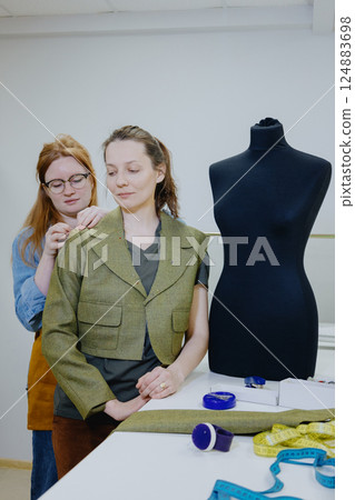Atelier sewing workshop. female seamstress, fashion designer, takes measurements . Atelier sewing workshop. female seamstress, fashion designer, takes measurements . 124883698