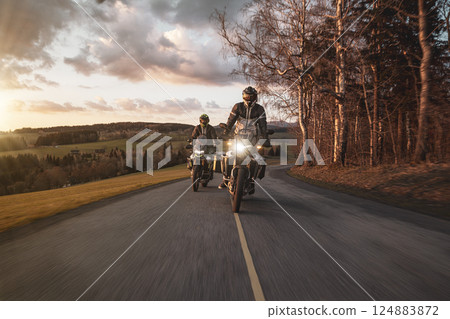 Two Drivers Riding Motorcycle on Empty Road During Sunset. 124883872
