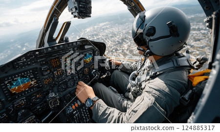 Pilot in cockpit flying military jet plane with advanced instrumentation over cityscape 124885317