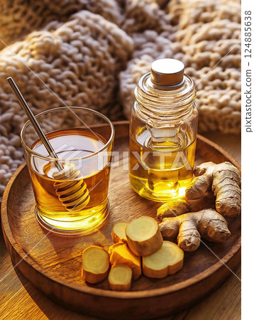 Cup of ginger tea with honey and essential oil on a wooden tray 124885638