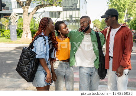 Diverse friends embracing during heartfelt street meeting, offering care and support to one another 124886023