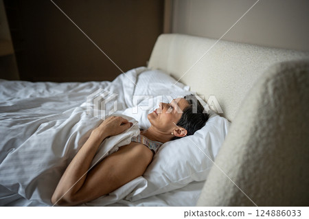 Tired mature woman lost in thoughts, staring at ceiling in bed, mental struggles with loneliness Tired mature woman lost in thoughts, staring at ceiling in bed, mental struggles with loneliness 124886033