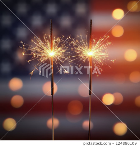 Celebrate freedom with sparklers in front of the American flag during a festive occasion 124886109