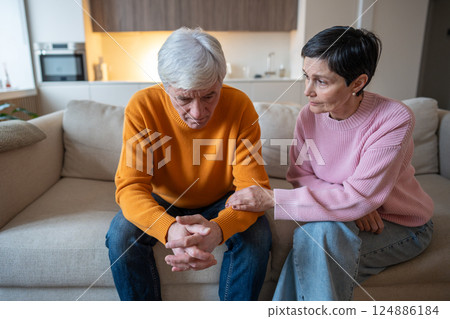 Supportive concerned wife comforts depressed husband, holding hand on couch during tough times Supportive concerned wife comforts depressed husband, holding hand on couch during tough times 124886184