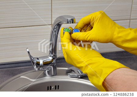 replacing a clogged faucet aerator in the kitchen sink replacing a clogged faucet aerator in the kitchen sink 124886238