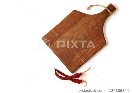 wooden cutting board and dried chili pepper pods isolated on white background. top view with copy space 124886244