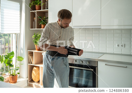 Man wearing back support corset on lower back to treatment of hernia, relieve stress on spine. Man wearing back support corset on lower back to treatment of hernia, relieve stress on spine. 124886380