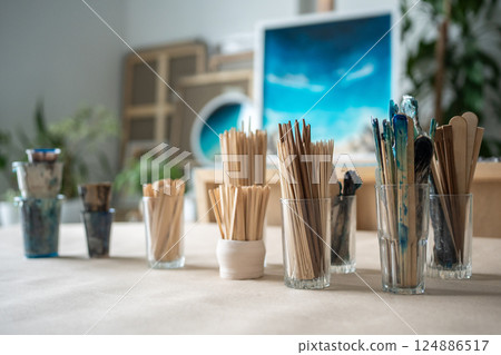 Crafting instruments for resin art on table, paintbrushes, stirrers, sculpting spatulas in workshop 124886517