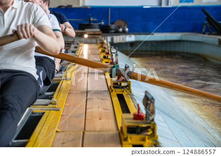 Rower arms in synchronized motion, paddling on simulator, strength flexibility and sport crew goal 124886557