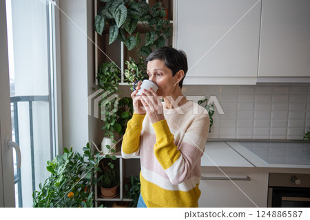 Pensive female enjoys tea, serene morning moment, relaxed anticipation, quiet time for yourself 124886587