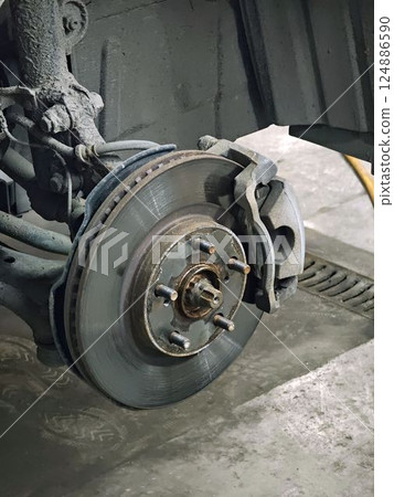 Car brake disc being inspected during maintenance in auto repair shop Car brake disc being inspected during maintenance in auto repair shop 124886590