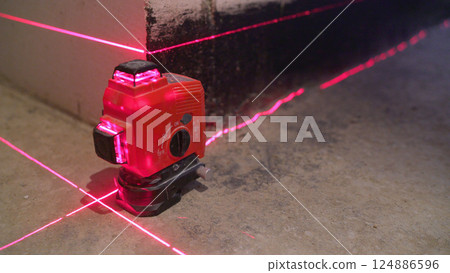 Repair concept. Red laser level on a construction site. Red laser level. Construction laser level. Repair concept. Red laser level on a construction site. Red laser level. Construction laser level. 124886596