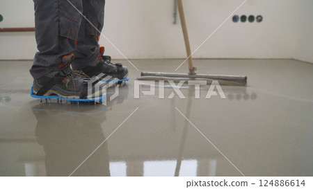 Construction worker vacuuming dust and debris on concrete floor 124886614