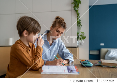 Schoolboy having lesson with private teacher at home 124886706