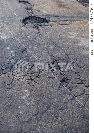 potholes in the road, holes in the asphalt on the roadway or highway.  124887509