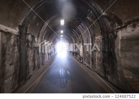 Tunnel with a light shining through it Tunnel with a light shining through it 124887522