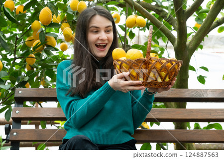 A woman and a basket of ripe lemons. Growing lemons 124887563