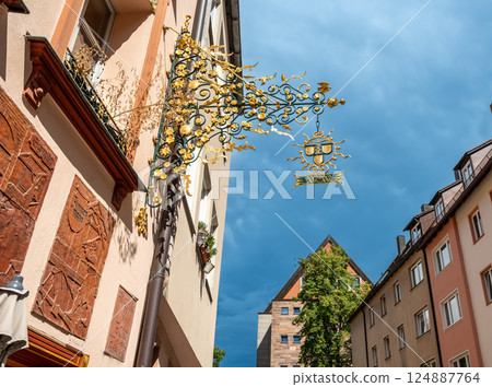 Nuremberg, Germany, August 1, 2023. The street of the tanners: it has all the charm of the old city, with the facades of the colorful and half-timbered houses. Detail of a wrought iron sign. 124887764