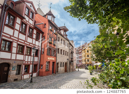 Nuremberg, Germany, 1 August 2023. The tanners' street: it has all the charm of the ancient city with the facades of the colorful and half-timbered houses. People walk along the stone-lined street. 124887765