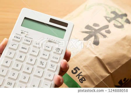 Hand holding a bag of rice and a calculator Hand holding a bag of rice and a calculator 124888058