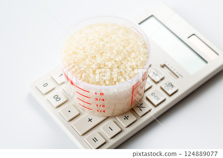 Rice in a measuring cup and a calculator 124889077