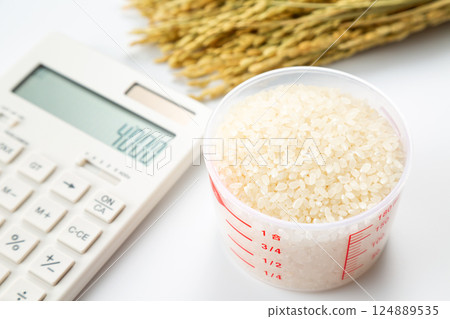 Rice in a measuring cup and a calculator 124889535