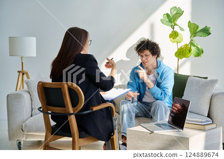 Young man in mental session talking with professional psychologist Young man in mental session talking with professional psychologist 124889674