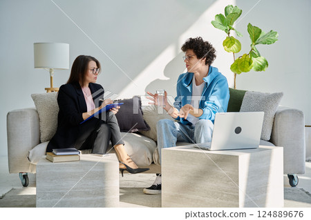 Mental therapy session, young guy talking with female psychologist, in office Mental therapy session, young guy talking with female psychologist, in office 124889676
