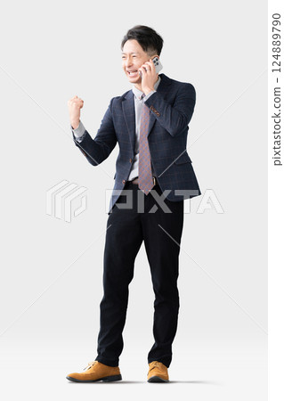 一名男子一邊用智慧型手機通話，一邊揮拳 124889790