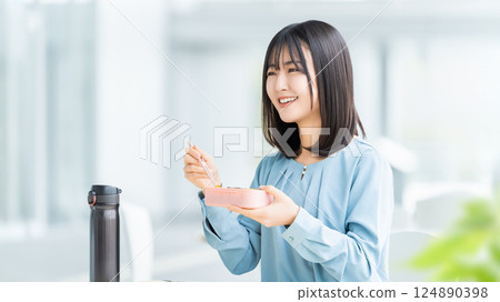 A woman/businesswoman eating lunch at lunchtime A woman/businesswoman eating lunch at lunchtime 124890398