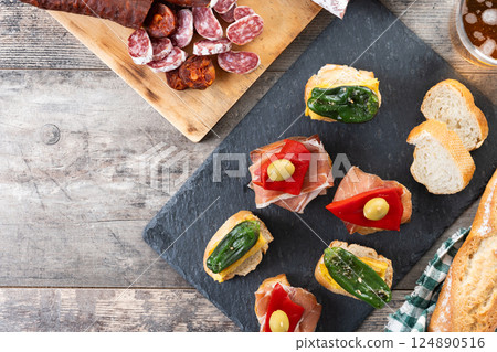 Traditional Spanish pintxos on wooden table 124890516