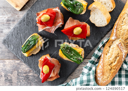 Traditional Spanish pintxos on wooden table 124890517