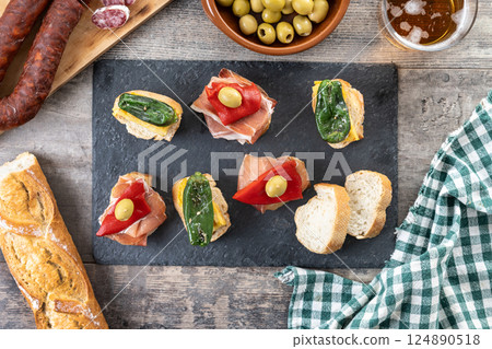 Traditional Spanish pintxos on wooden table Traditional Spanish pintxos on wooden table 124890518