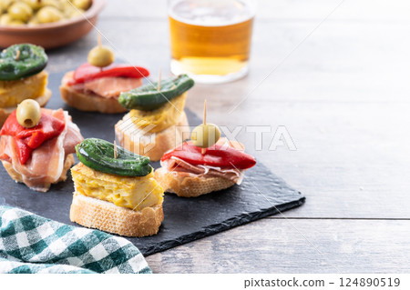 Traditional Spanish pintxos on wooden table 124890519