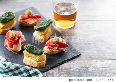 Traditional Spanish pintxos on wooden table Traditional Spanish pintxos on wooden table 124890563