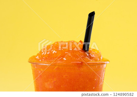 Orange slushie on yellow background Orange slushie on yellow background 124890582