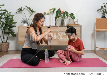 Exercise and Nutrition. A fitness enthusiast teaching a child the importance of hydration. 124890812