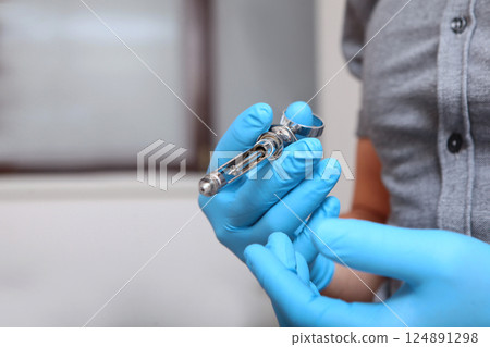 Syringe is in hand. Hand in protective glove holds syringe for injection. Concept of modern medicine. Close-up. With space for copying. Syringe is in hand. Hand in protective glove holds syringe for injection. Concept of modern medicine. Close-up. With space for copying. 124891298