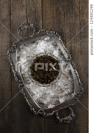 Black caviar on a crystal plate. Ice on tray. Black caviar is on ice. Natural omega. Flat lay. Top view. Copy space. Black caviar on a crystal plate. Ice on tray. Black caviar is on ice. Natural omega. Flat lay. Top view. Copy space. 124891299