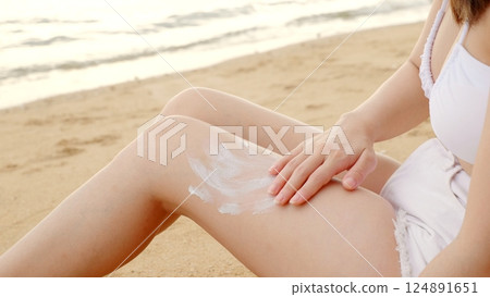Beautiful Asian woman apply sun protection cream on tanned on leg at tropical beach with white sand, Sun Cream Skincare, Close up female in bikini using sunscreen lotion on back body before sunbathing Beautiful Asian woman apply sun protection cream on tanned on leg at tropical beach with white sand, Sun Cream Skincare, Close up female in bikini using sunscreen lotion on back body before sunbathing 124891651