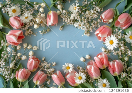Fresh pink tulips and daisies arranged beautifully on a blue background for spring decorations 124891686